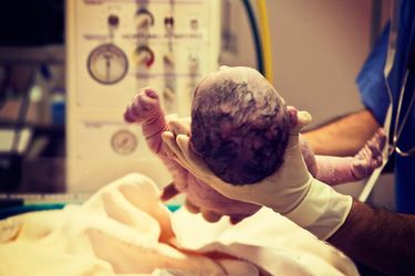 A doctor holds a newborn baby
